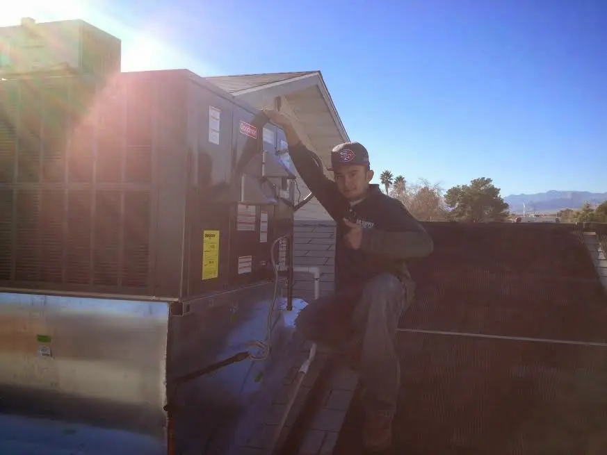 HVAC technician performing Heat Pump Repair on a rooftop unit in Coronado